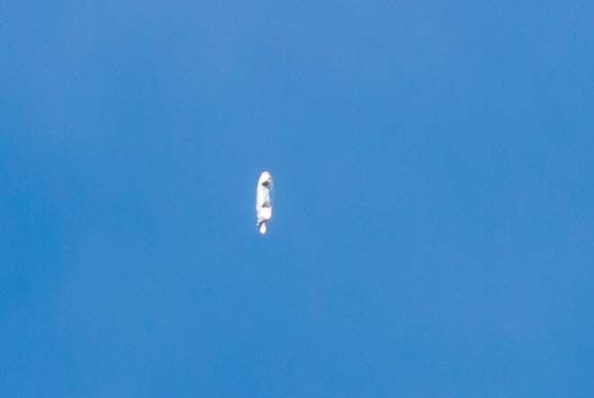 Een metaalachtig object waarop de zon weerkaatste, dat zich langzaam voortbewoog foto