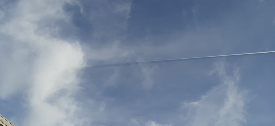 Vliegtuig volgt zwart luchtspoor foto