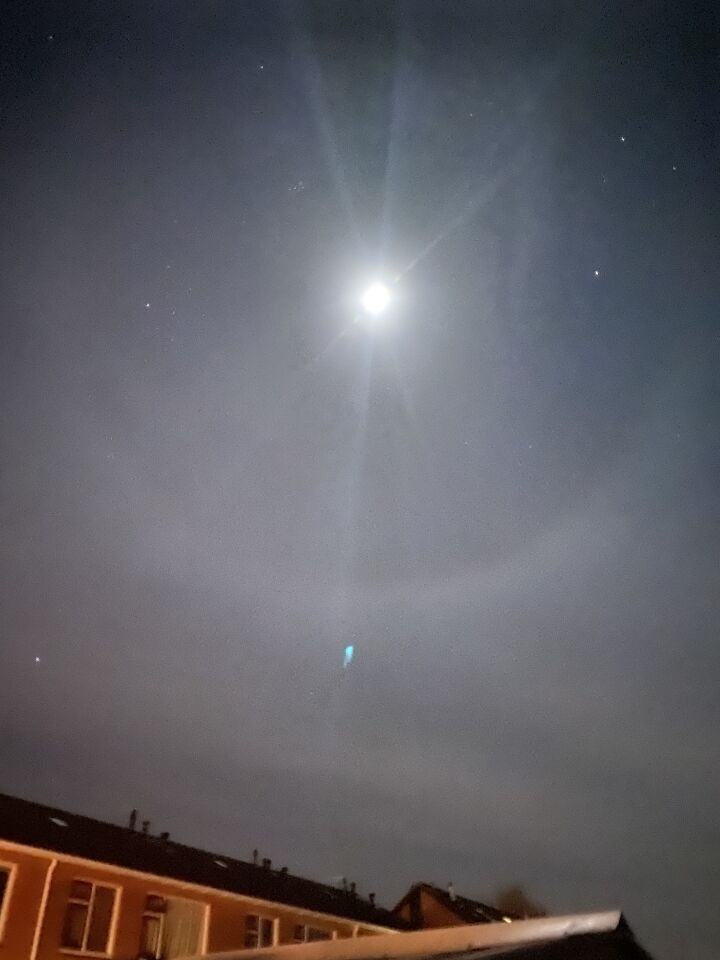 Blauw licht richting de maan met halo foto