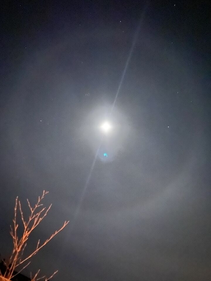 Blauw licht richting de maan met halo foto