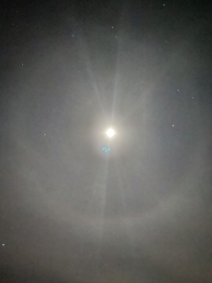 Blauw licht richting de maan met halo foto