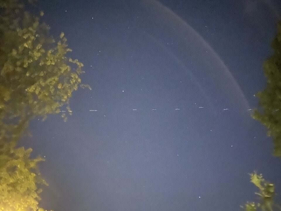 Lange formatie witte lichtjes (70+), ze vliegen richting het Noorden. foto