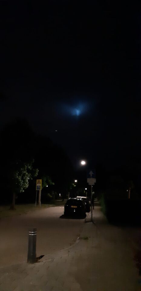 Groot verticaal lichtgevend blauw object met kleine lichtgevende bal foto