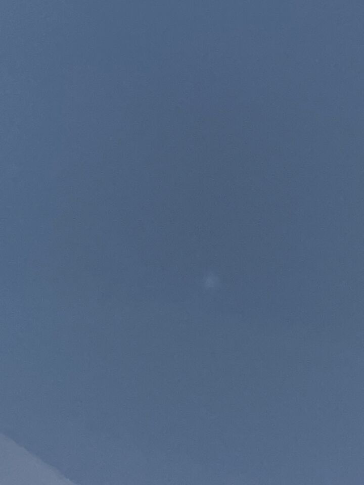 Een lichtpunt omgeven door een mist-bol, bij heldere hemel foto