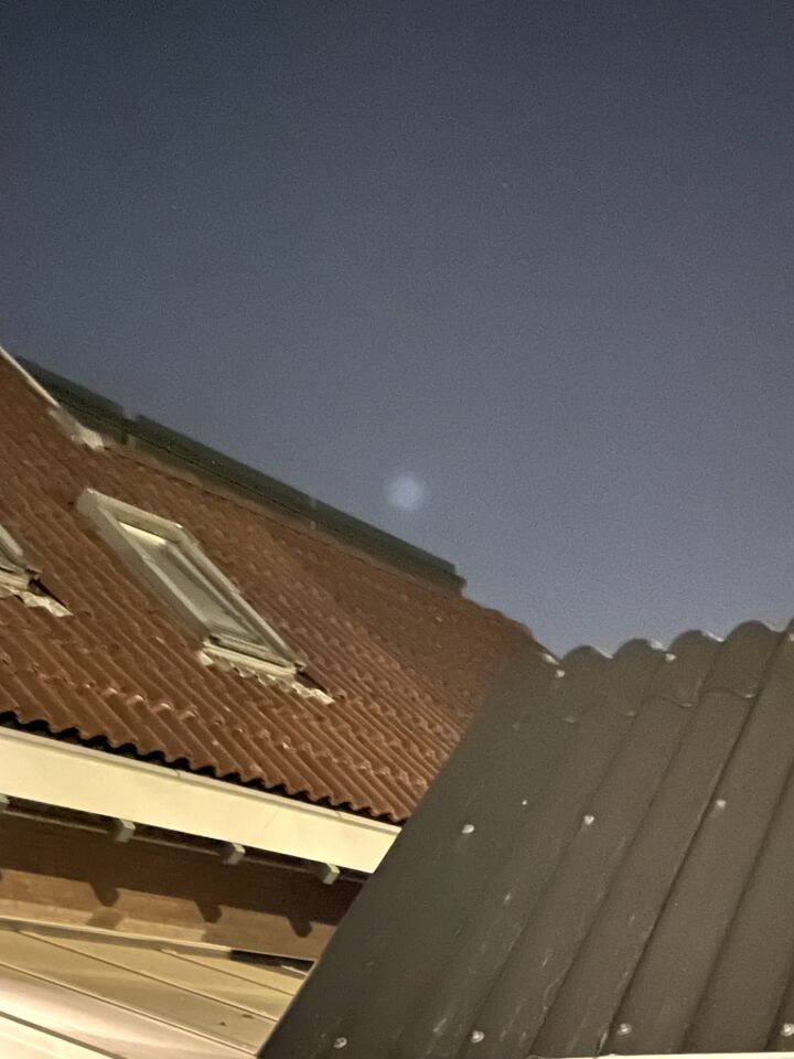 Een lichtpunt omgeven door een mist-bol, bij heldere hemel foto