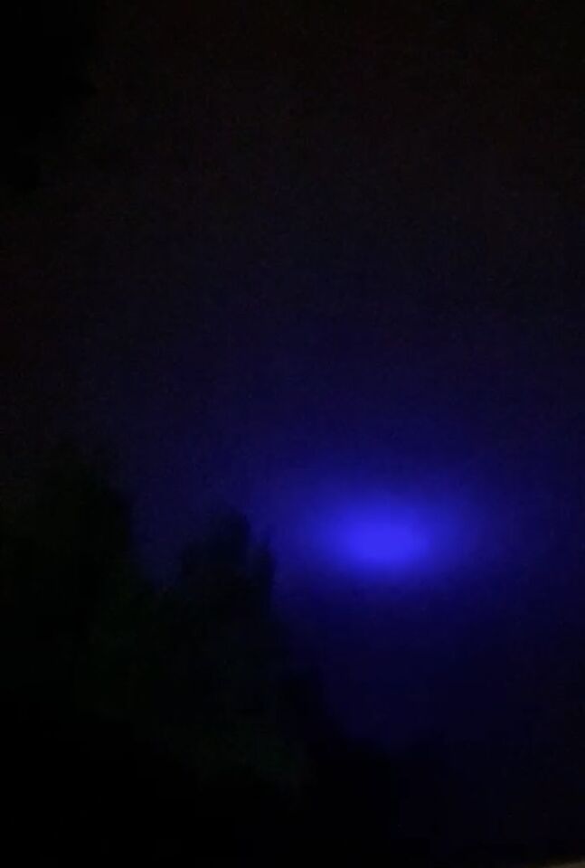 Blauw licht wat van fel, dimde en erna weer fel werd ! Tussen de wolken foto