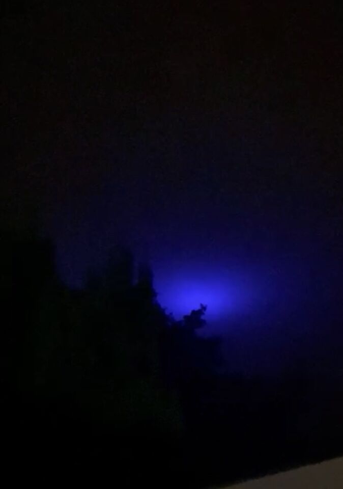 Blauw licht wat van fel, dimde en erna weer fel werd ! Tussen de wolken foto