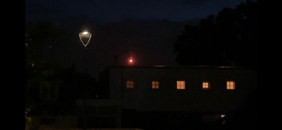 Een rood, sterk lichtgevende slingerende bol, liet kleine bollen vallen foto
