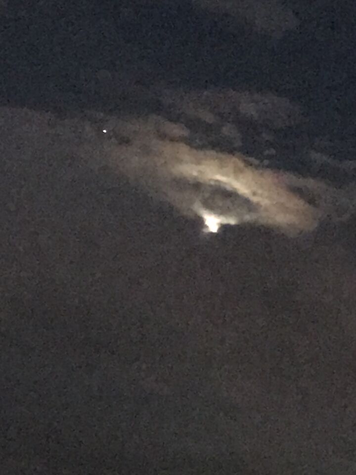 In de wolken een UFO vorm. Licht aan de onderkant. foto