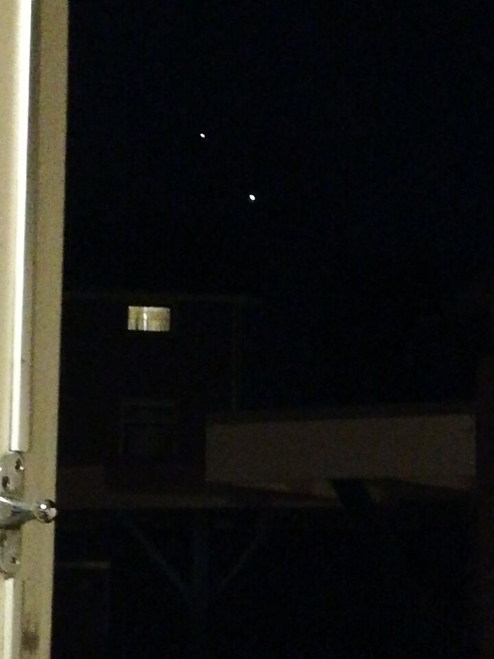 Zag 2 felgekleurde objecten hangen in de lucht. Groter dan een ster foto