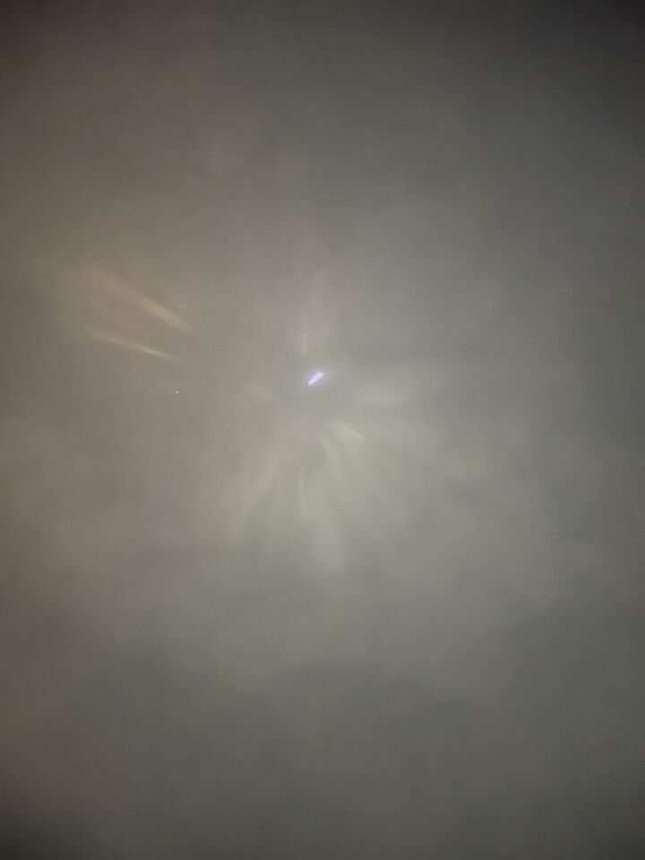 Stilstaand lichtpunt met daaromheen lichtstralen. foto