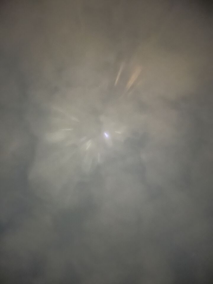 Stilstaand lichtpunt met daaromheen lichtstralen. foto