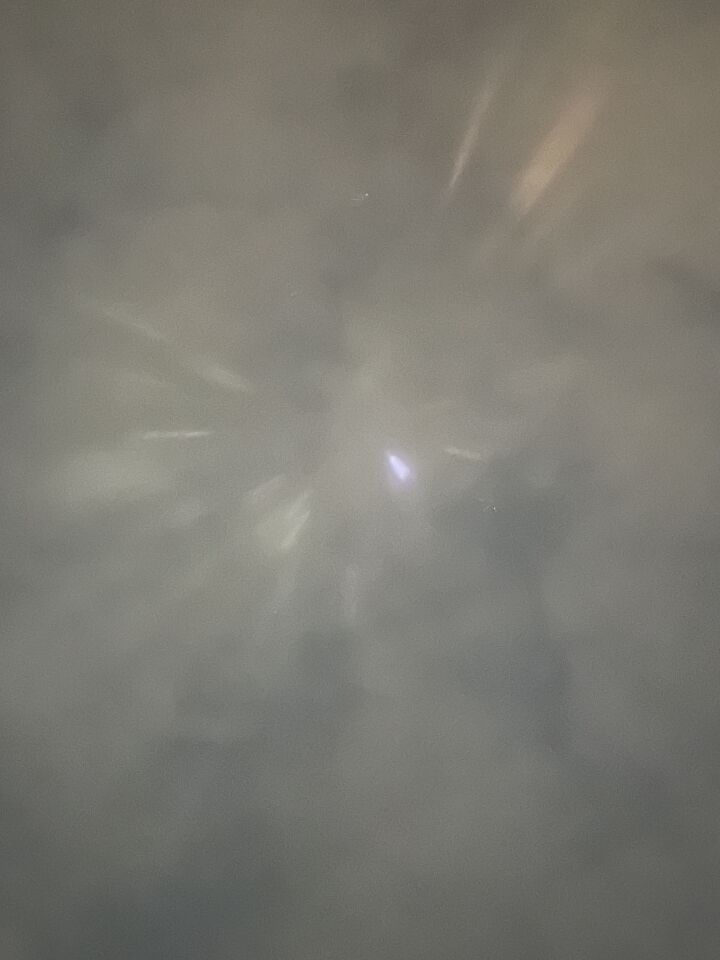 Stilstaand lichtpunt met daaromheen lichtstralen. foto