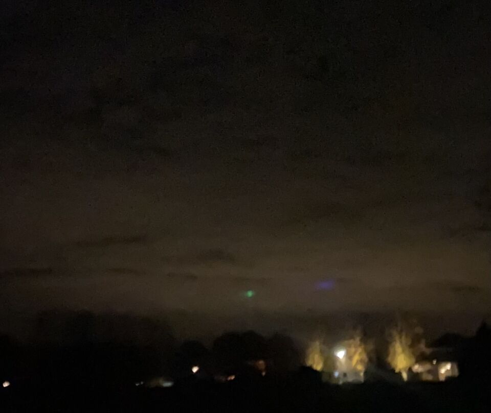 Groen bol achtig object met mist waas er omheen en lichtstraal naar aarde foto