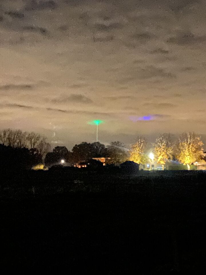 Groen bol achtig object met mist waas er omheen en lichtstraal naar aarde foto