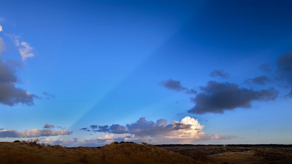 Vreemde donkere lichtbundel en ovaal object in de lucht foto