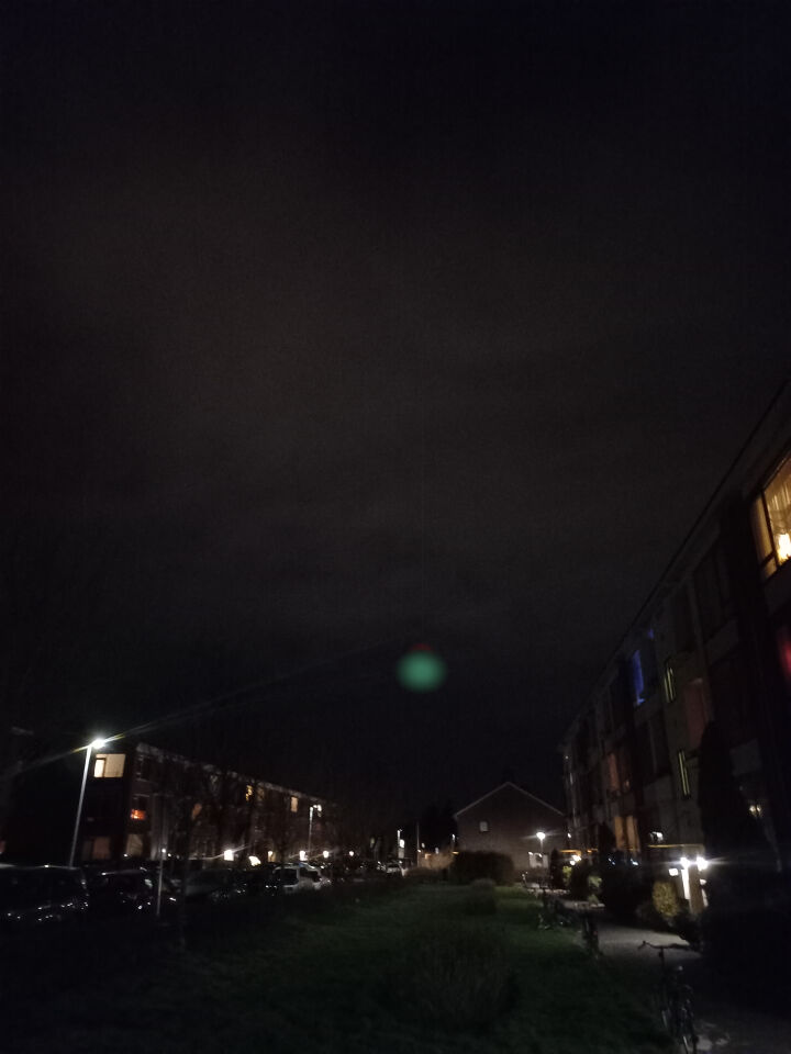 Een groene lichtbol met een rode gloed die met grote snelheid uit de lucht viel. foto