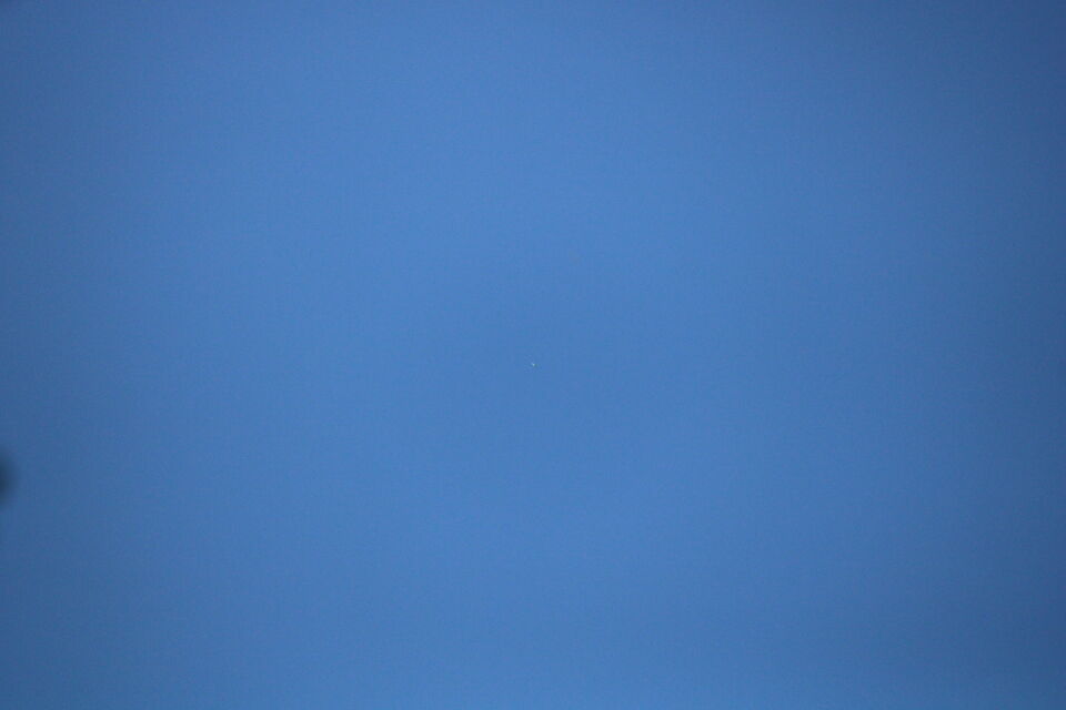 Hoog in de lucht een moeilijk te identificeren object dat lang op dezelfde plek foto