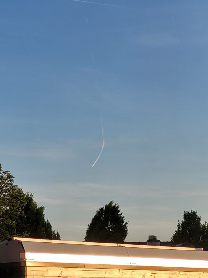 Een bewegende contrail die naar de beneden boog, leek iets neer te storten. foto