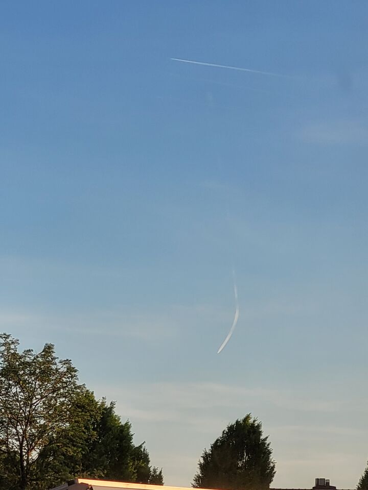 Een bewegende contrail die naar de beneden boog, leek iets neer te storten. foto