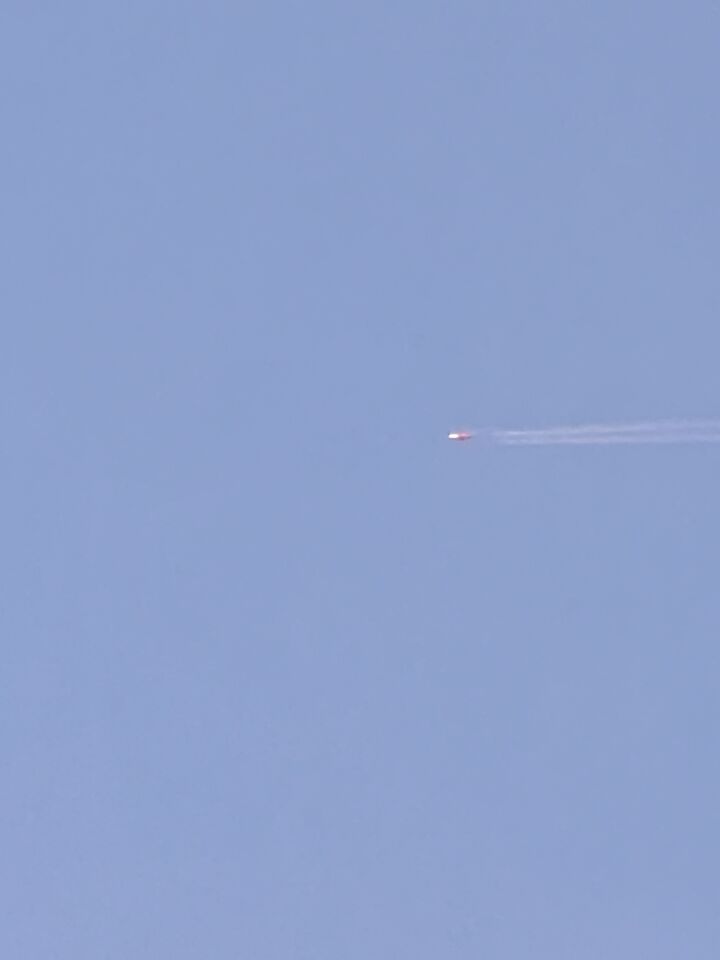Een ovaalvormig rood object vliegt eerst recht daarna met neus naar beneden foto