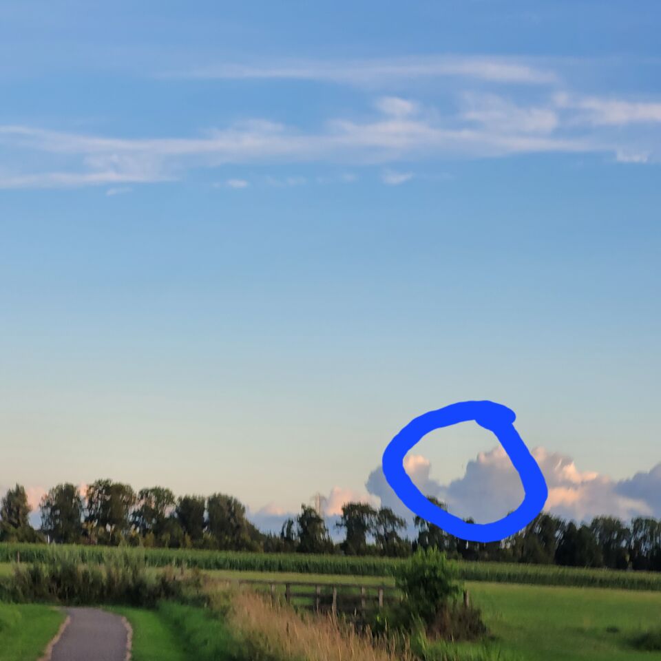 Ronde bol(grijsachtig) tussen wolken foto