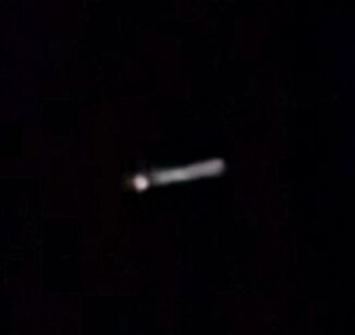 Lichtgevende sigaar vormige UFO. 1 punt ervoor maar wel verbonden met elkaar. foto
