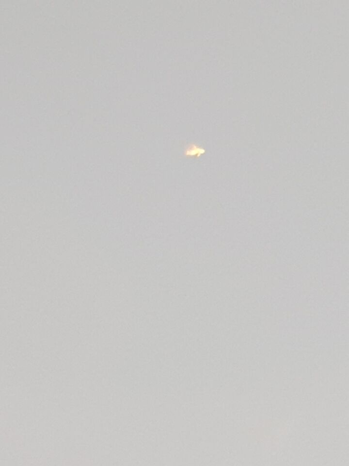 Een oranje voorwerp dat als een vliegtuig door de lucht heen vloog foto