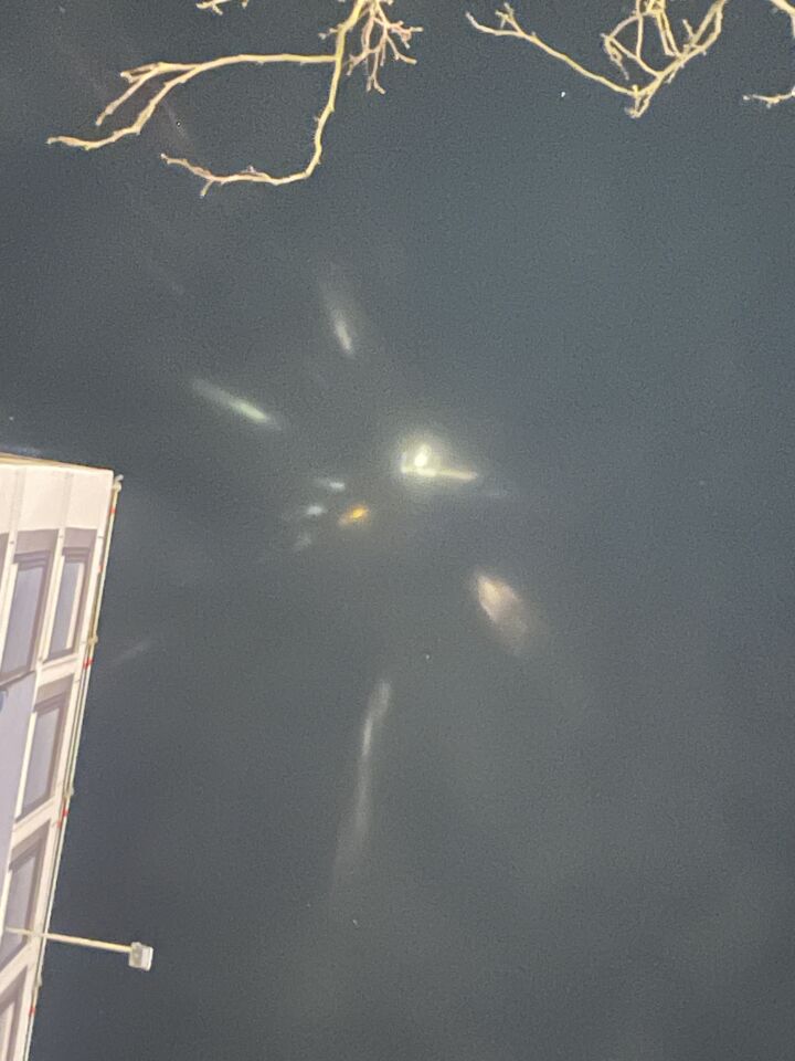 4 witte en oranje lichtenpunten met daaromheen lichtstrepen foto