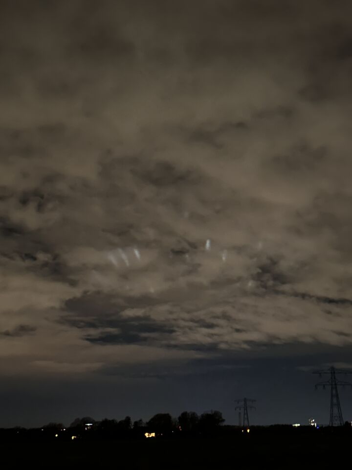 Ronde vorm met lichtpunten boven wolken, lichtstralen die omhoog reflecteren foto