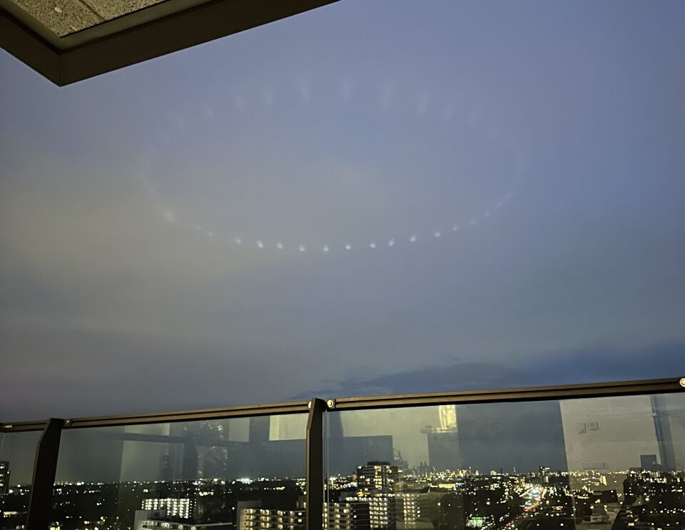 Ronde lichtformatie hoog in de avondlucht boven de stad foto