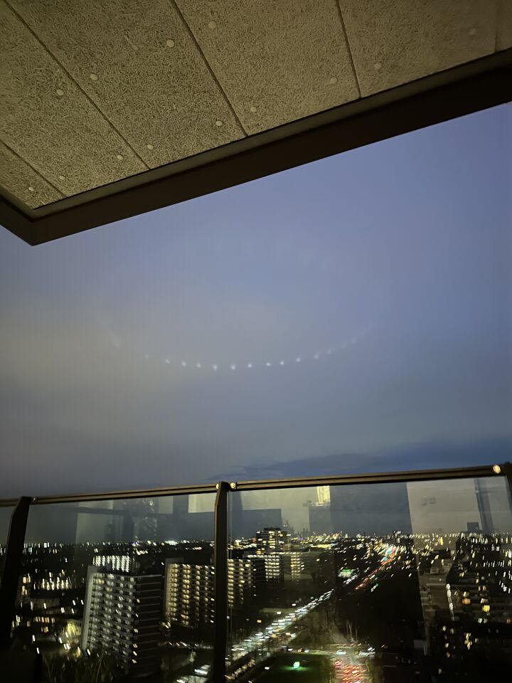Ronde lichtformatie hoog in de avondlucht boven de stad foto