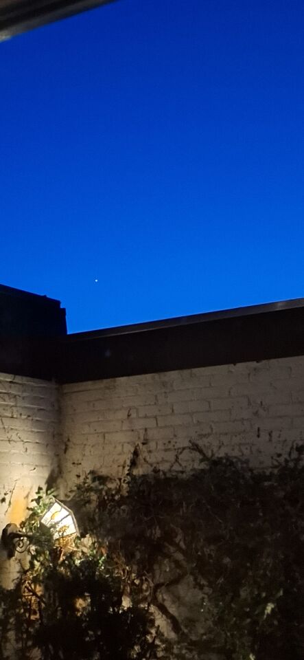 Fel wit licht 3 puntig stervormig hangt stil in de lucht boven Beverwijk foto