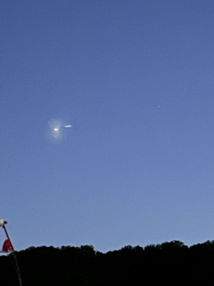 In mistgehulde lichtbol met langwerpig licht erachter. Langzaam zuidwaarts foto