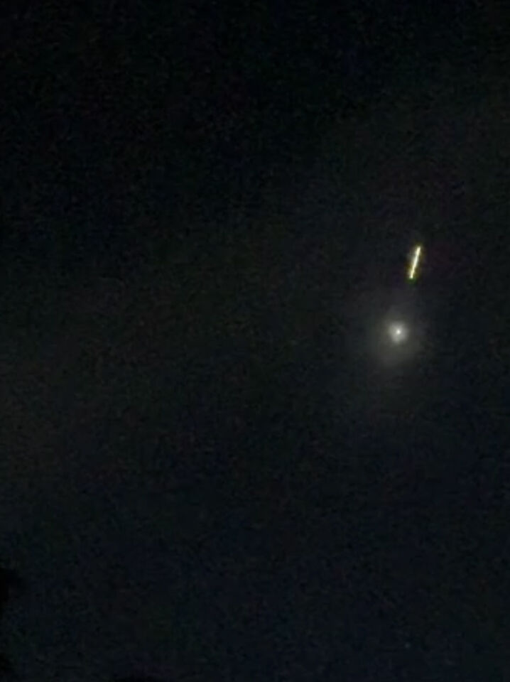 Een gloeiende bol met daarop volgend een lijn van licht foto