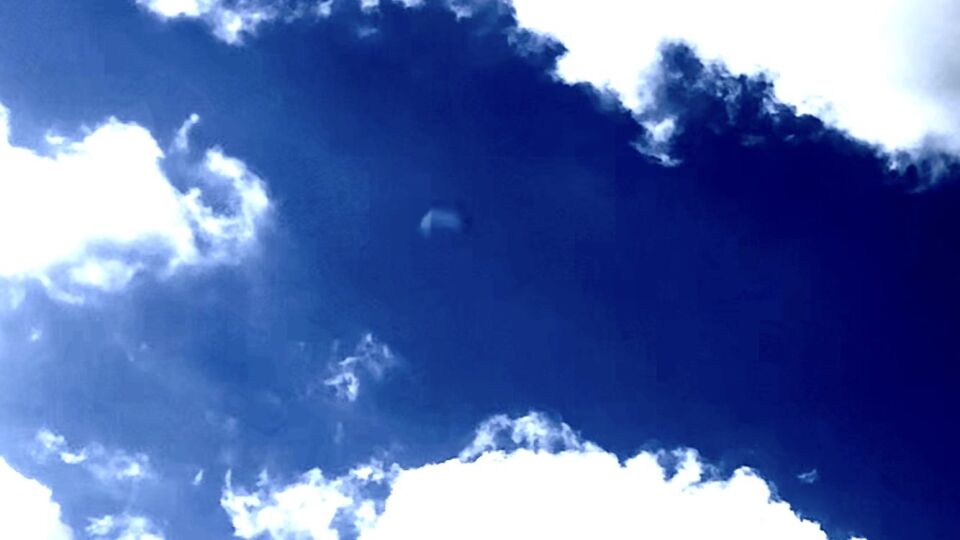 Blauwe bol UFO gaat super snel een wolk in en dan één sec later er uit gefilmd. foto