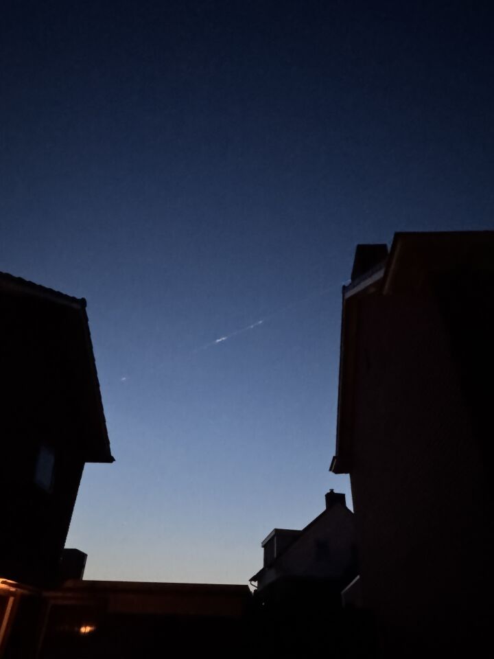 Langgerekt brandend voorwerp met uitlaatstrepen/rookspoor door de lucht foto