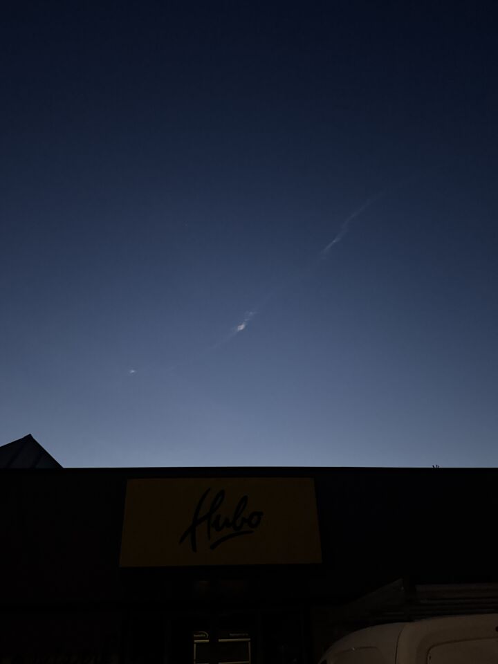 Langgerekt brandend voorwerp met uitlaatstrepen/rookspoor door de lucht foto