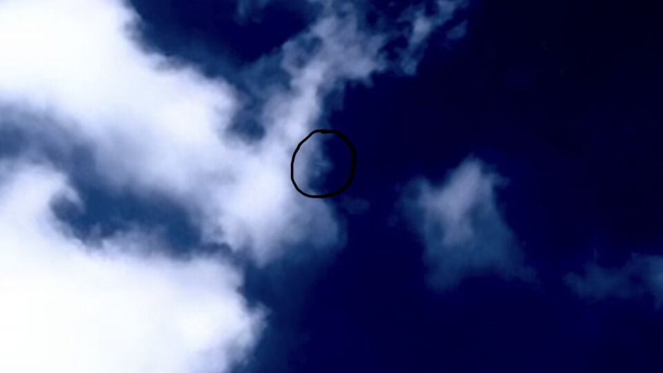 UFO komt snel uit de lucht, gaat achter een wolk en laat zichzelf even snel zien. foto