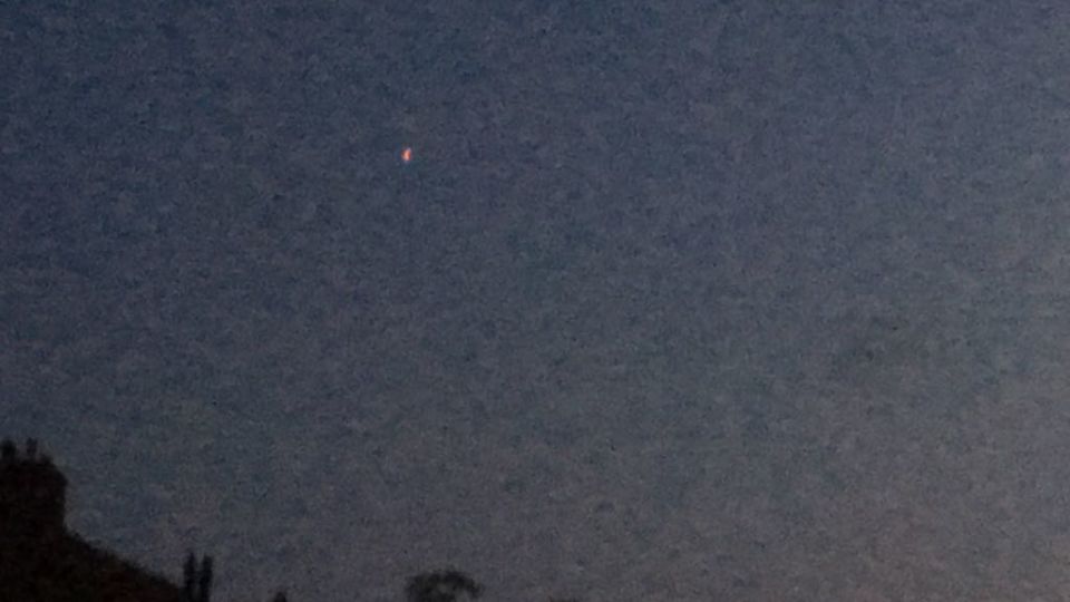 UFO met fel oranje/rood licht foto