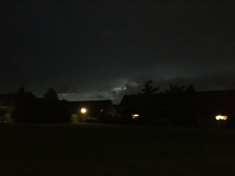 Fel licht tussen de donkere wolken en silhouet van immens vliegtuig + ronde bol foto