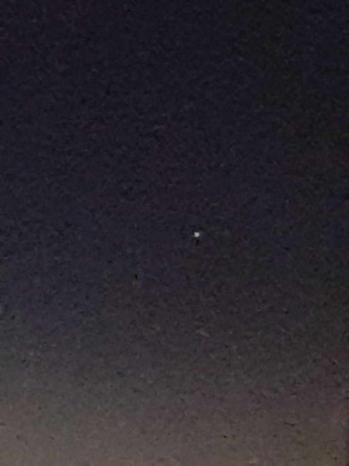 Een lichtbol dat knipperd van rood naar een groen achtige kleur het blijft zweve foto