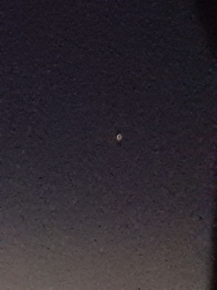 Een lichtbol dat knipperd van rood naar een groen achtige kleur het blijft zweve foto