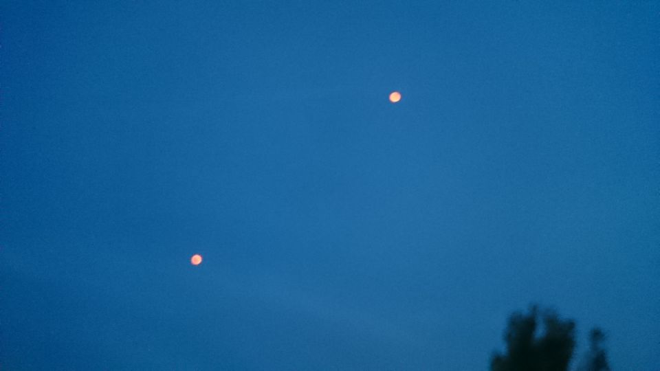 2 oranje lichten vlogen op gelijke snelheid naast elkaar. Langzaam uit elkaar foto