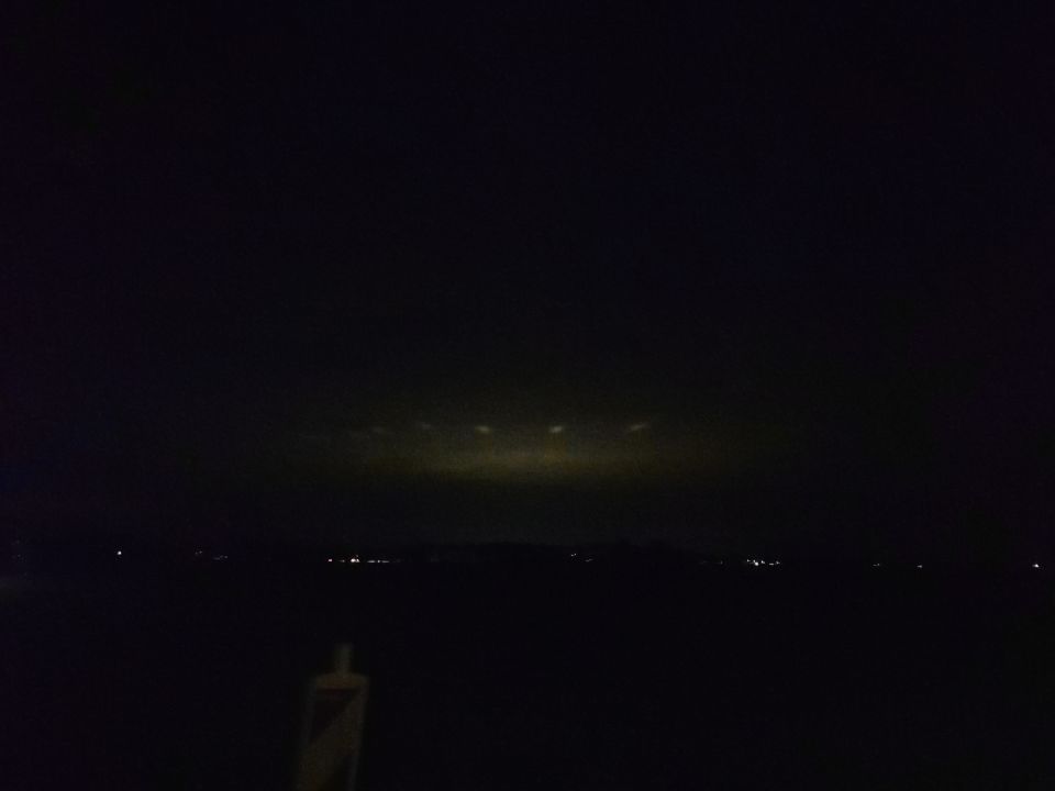 Een enorm groot licht met daarom heen kleinere lichten in de lucht foto