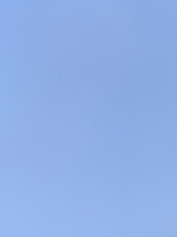 Zwarte vliegende bol tegen de blauwe lucht foto