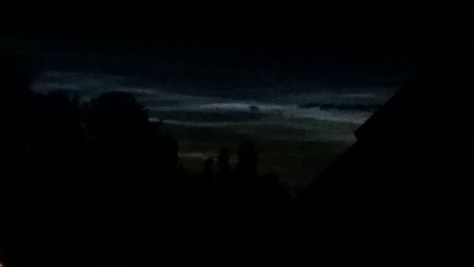Enorm oplichtend en fel blauwe luchtbaan tijdens donkere nacht met voorwerp foto