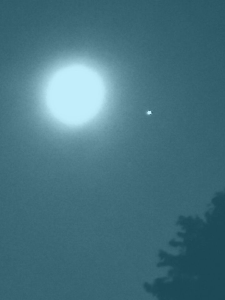 Stilstaande witte bol rechts onder de maan foto