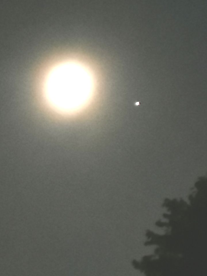 Stilstaande witte bol rechts onder de maan foto