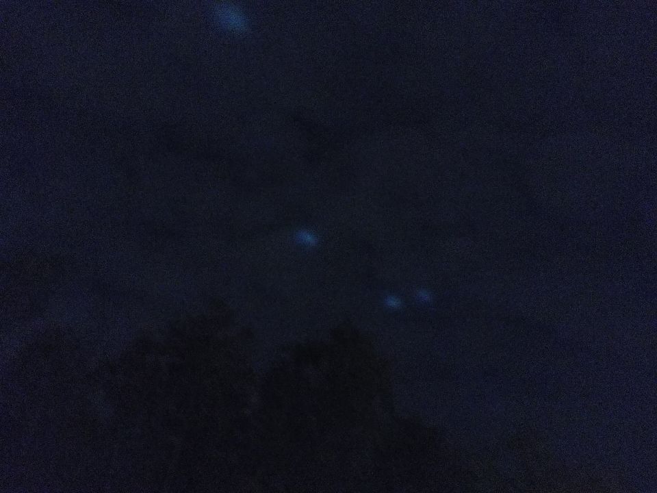 5 lichtbollen schijnen door de wolken heen ze zijn steeds in beweging wit licht foto